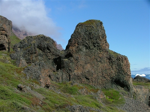 Behind Qeqertarsuaq lies the basalt rocks, famous at Disko island