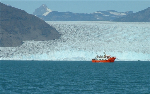 Boat trip on the Qoorooq fjord. Normally the fjord is packed with icebergs and lumps of ice. However, on this picture the strong foehn winds have cleansed the fjord from ice. The massive and high glacier front from where ice is constantly calved off is seen in the background