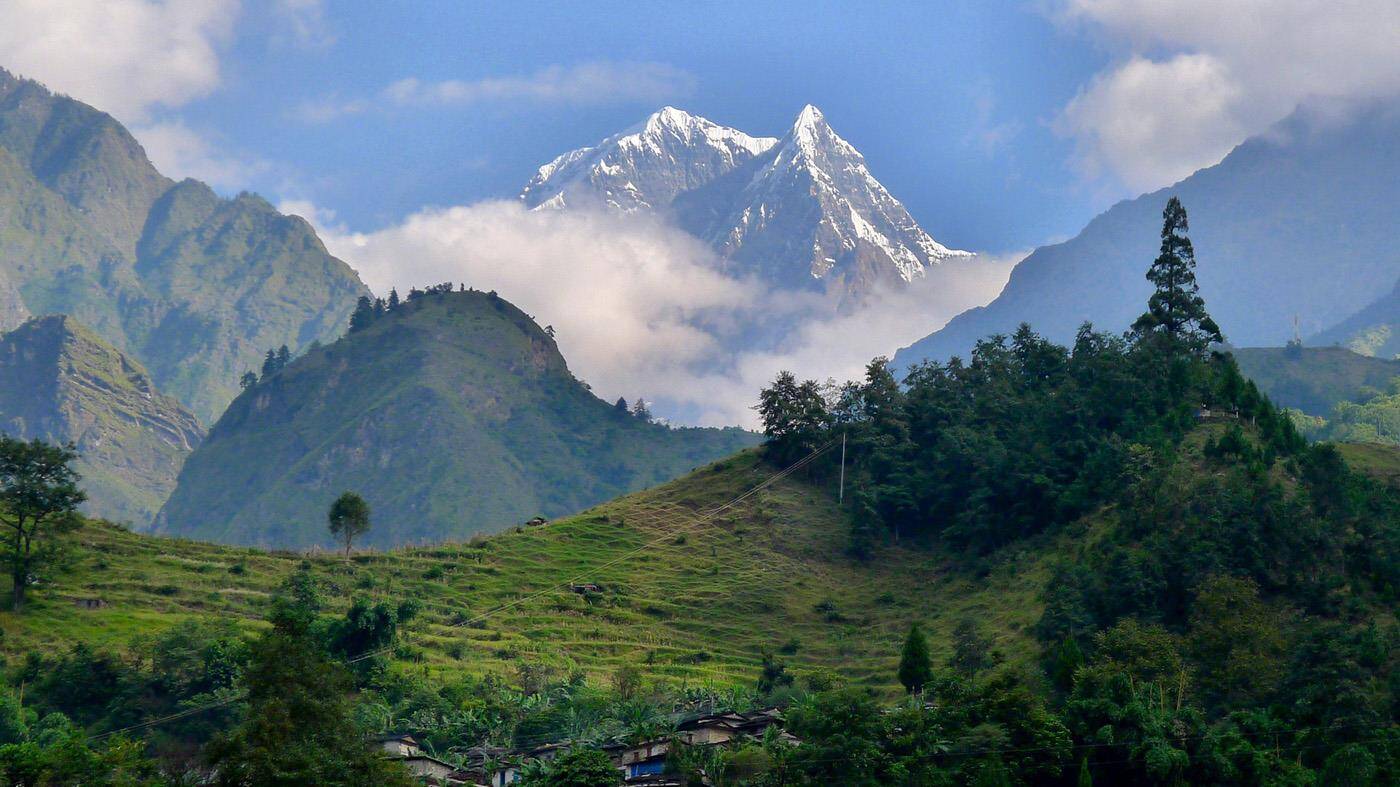 Manaslu udsigt over træer, bakker og fjeld. 