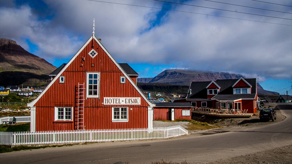 Hotel Disko Islands rødmalede bygning med hvidt stakit på Diskoøen. 