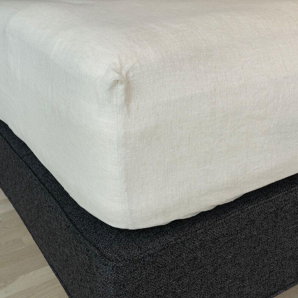 Hamp lagen i beige sidder pænt på en seng.