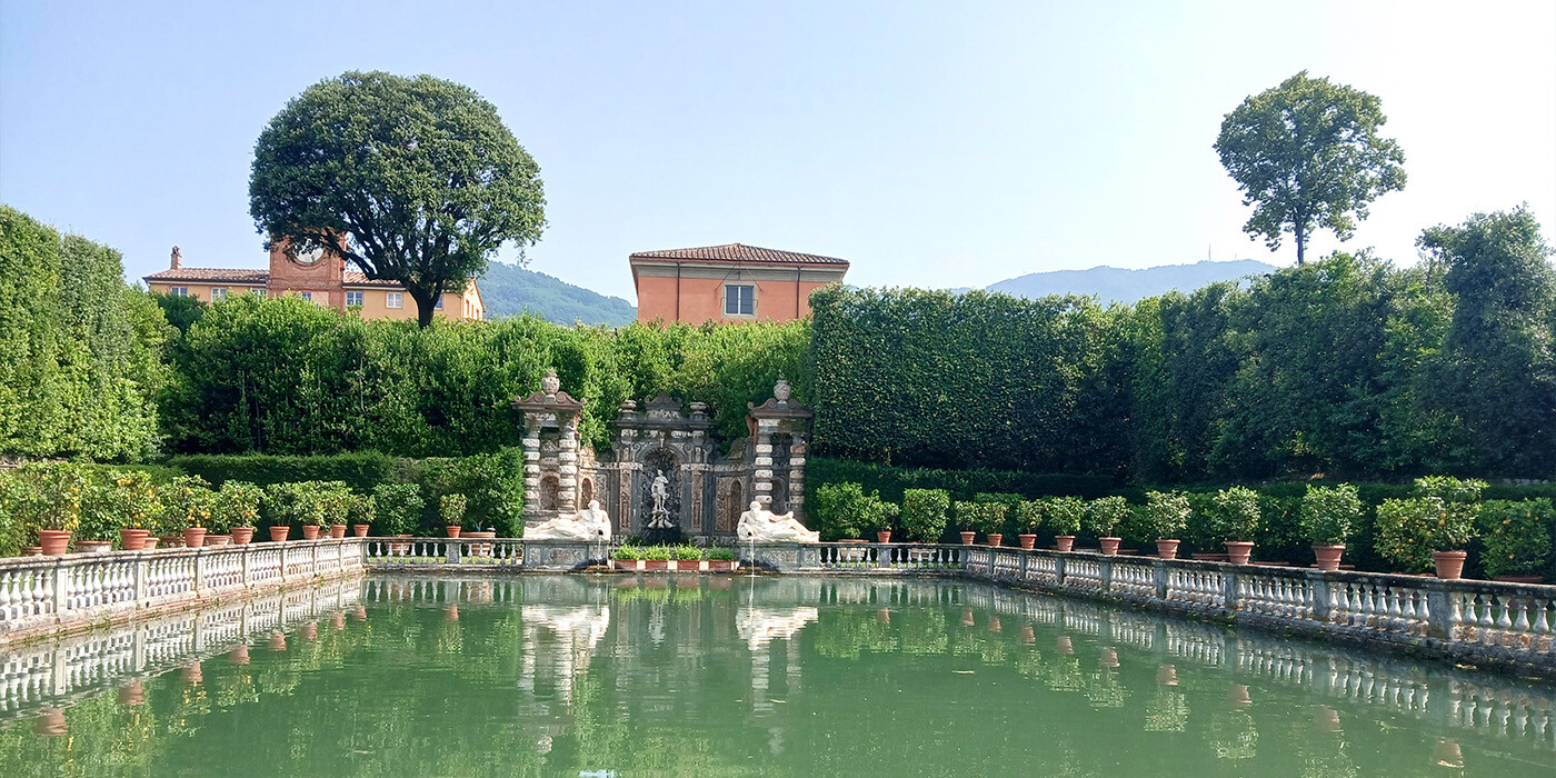Bassin foran villa med veltrimmede hække i Toscana