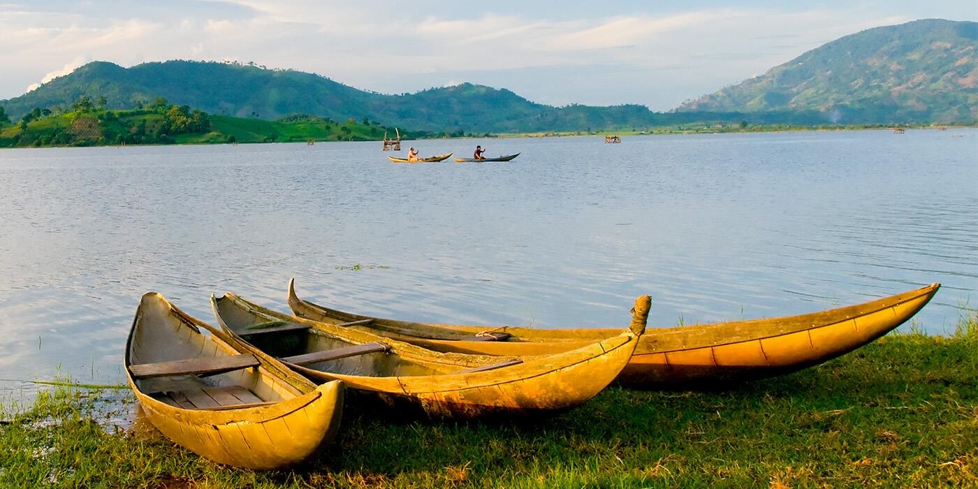 Lak Lake i Vietnam med robåde i vandet og bjerge i horisonten