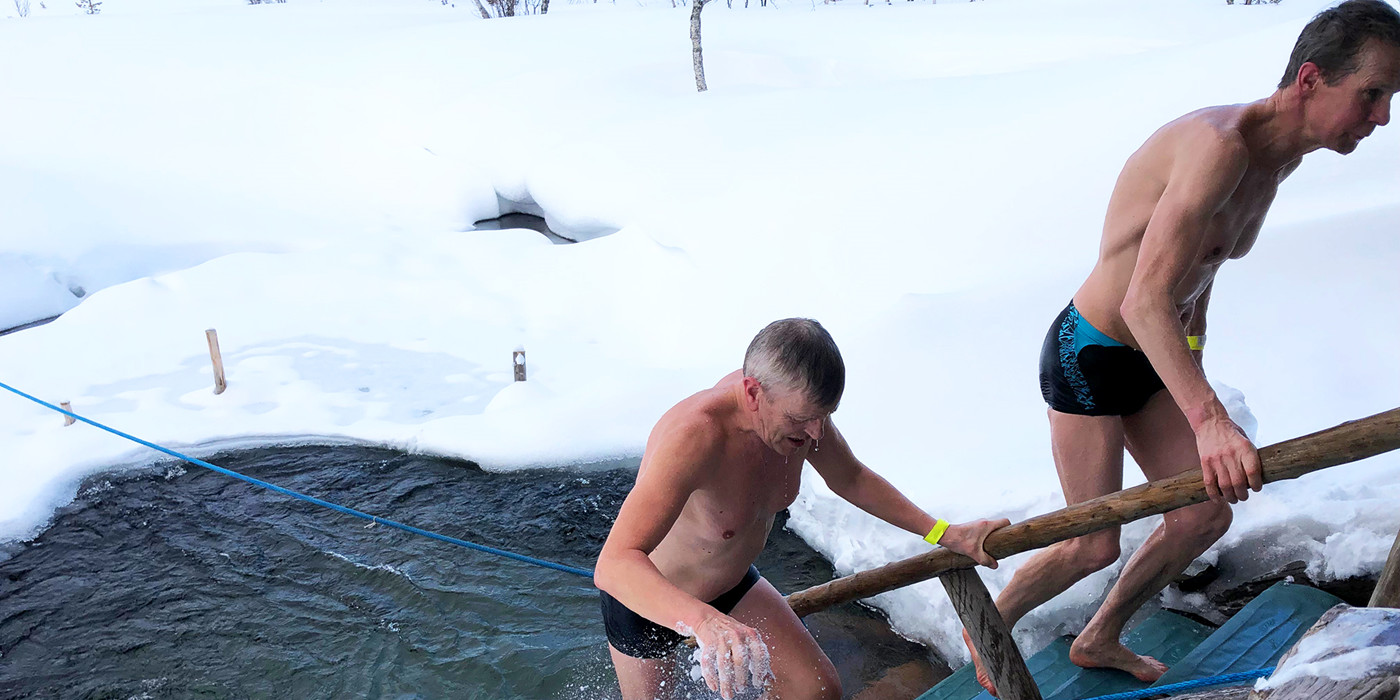 To mænd på vej op af vandet efter isbadning. 