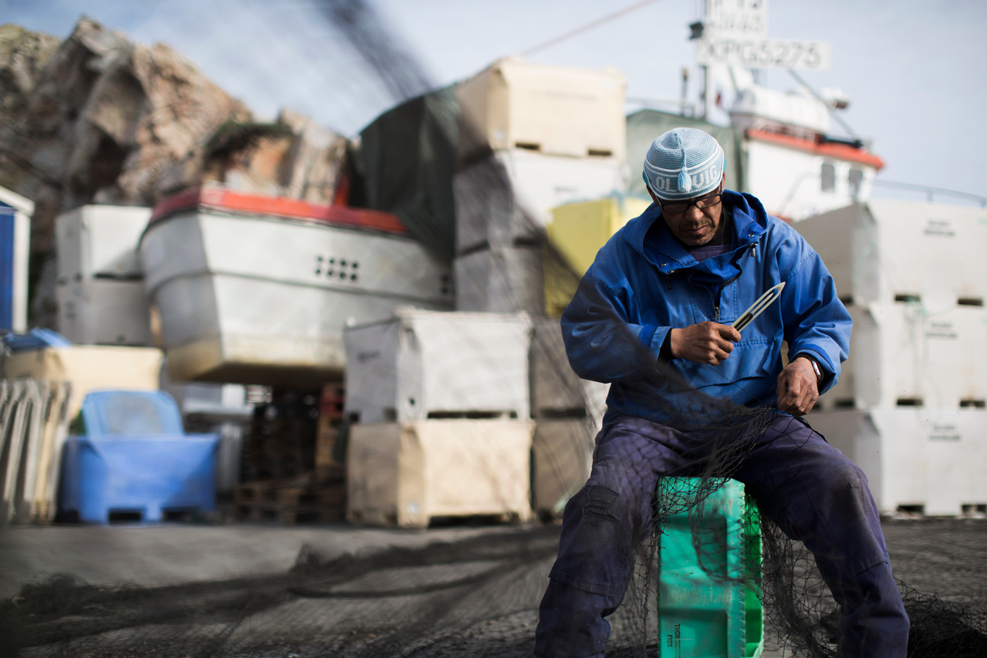 Grønlandsk fisker arbejde med fiskenet på havnen. 