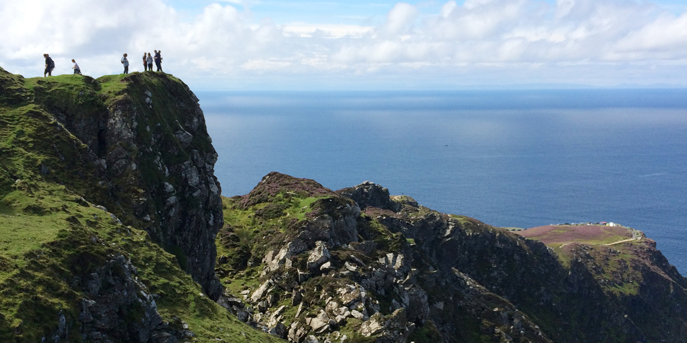 Vandrere nyder udsigten over havet fra Slieve League i Irland.