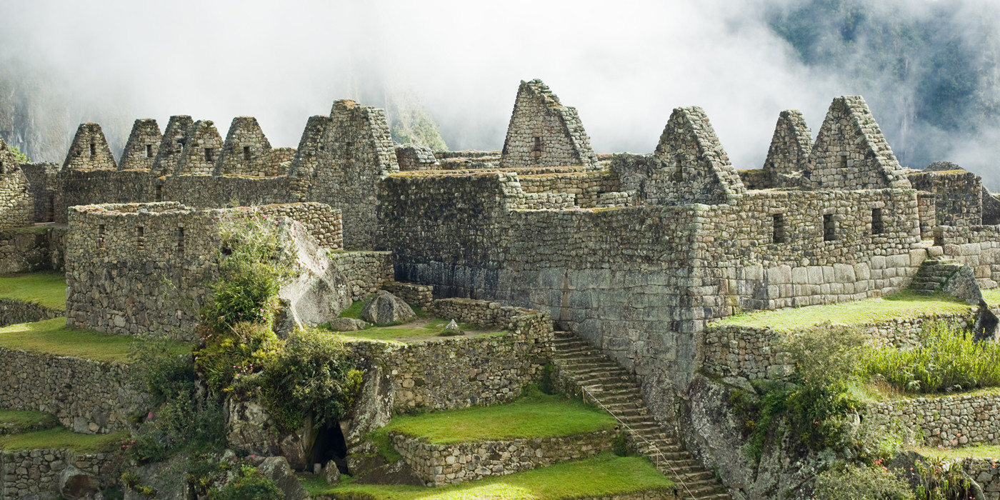 Ruiner i Machu Picchu, med skyer drivende henover. 