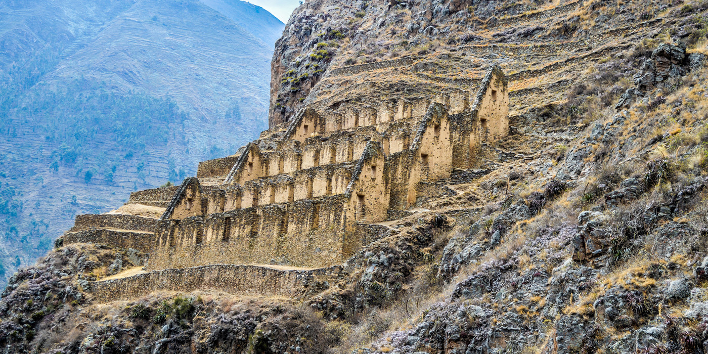 Ruiner langs bjergside i Peru.