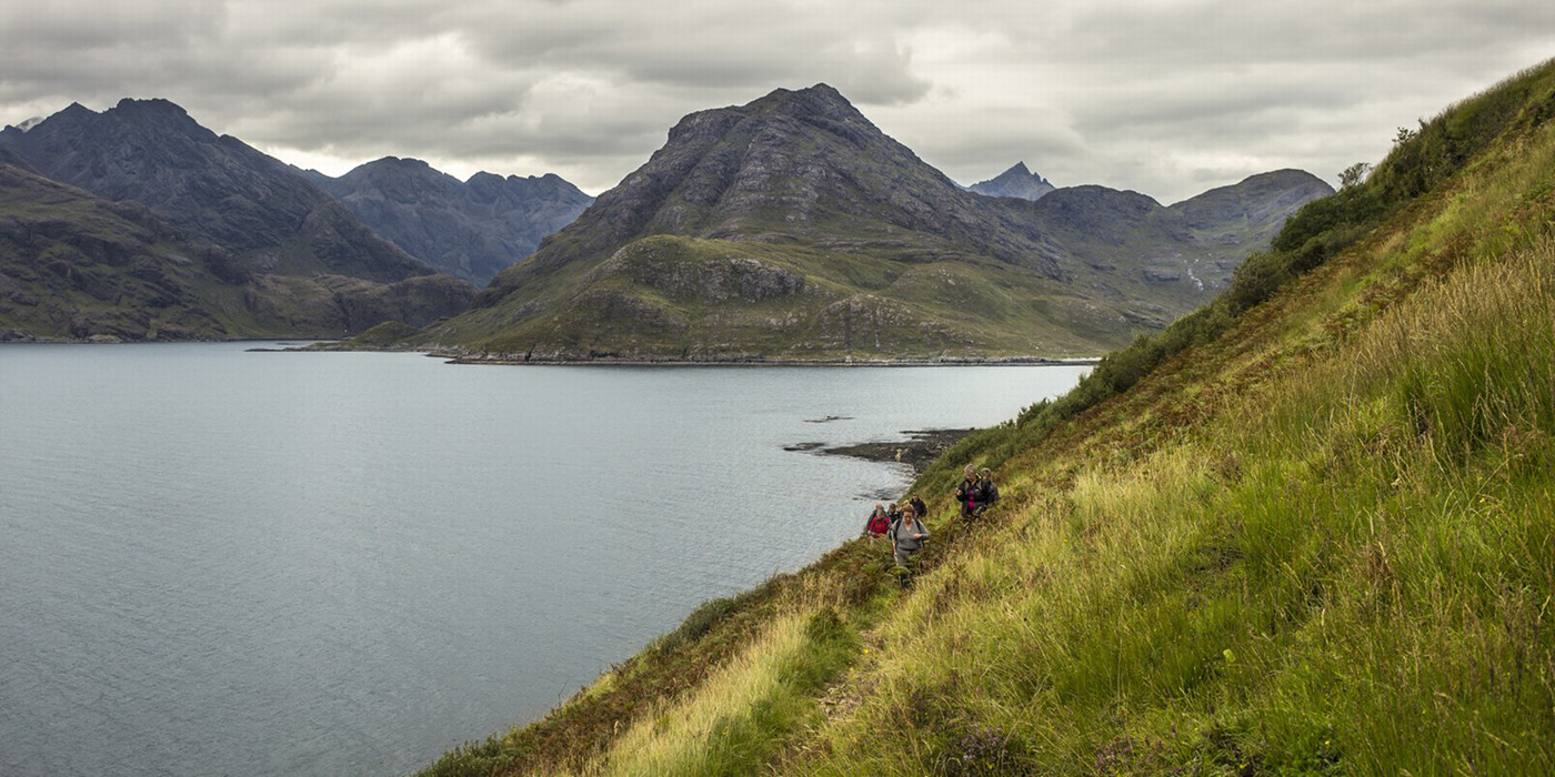 Vandrere nyder udsigt fra bjergside ved Isle of Skye. 