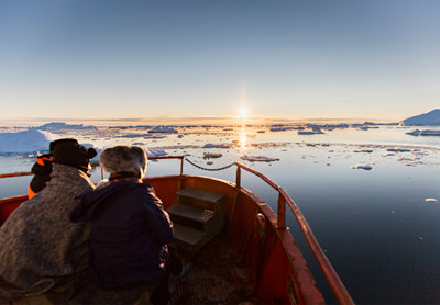 To personer nyder udsigten over isfjorden.