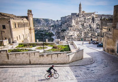 Cyklist kører gennem gaderne i Matera, Italien. 