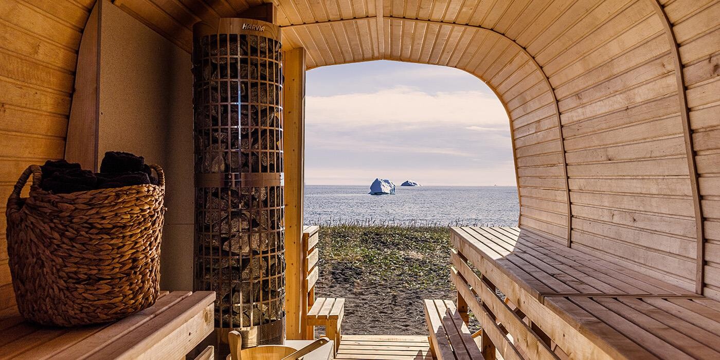 Sauna at black sand beach with view of sea and icebergs.