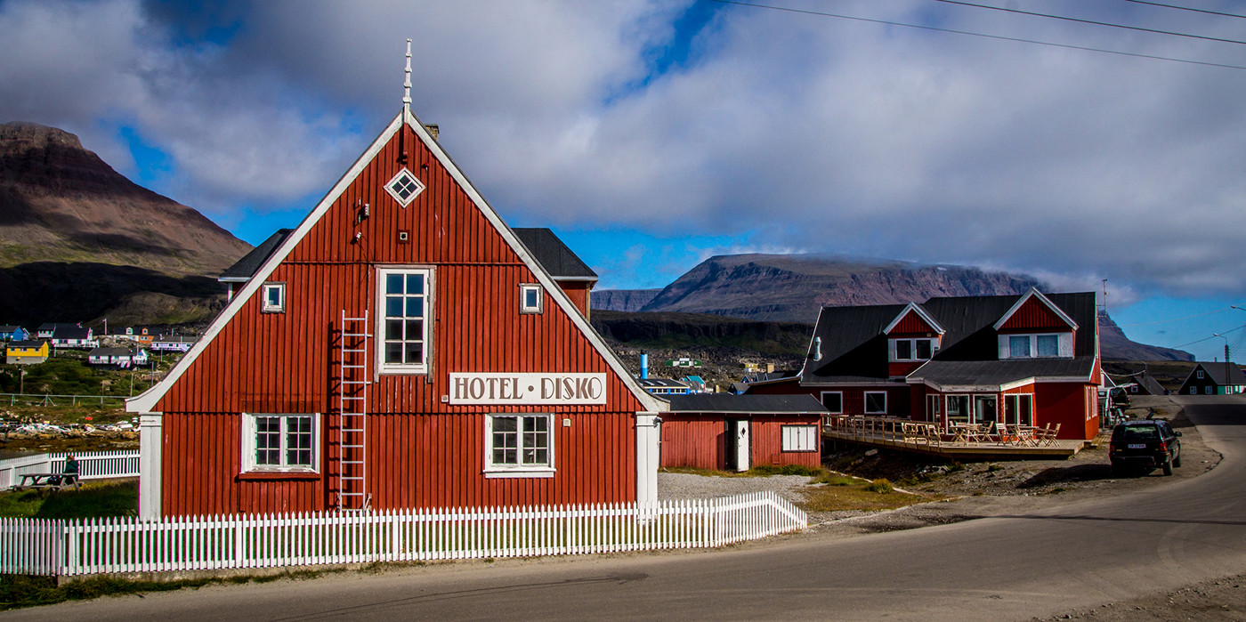 Hotel Disko Islands facade med bjerge i baggrunden