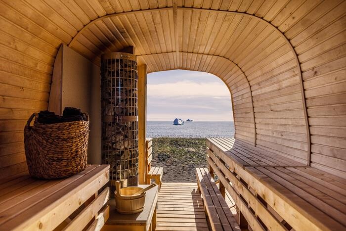 View from inside sauna on black sand beach with a view of the sea and its icebergs.