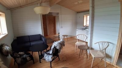 Igaliku guesthouse interior with sofa, chairs and kitchen.