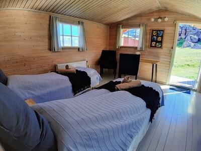 Igaliku cabin interior with beds, chairs and desk. 